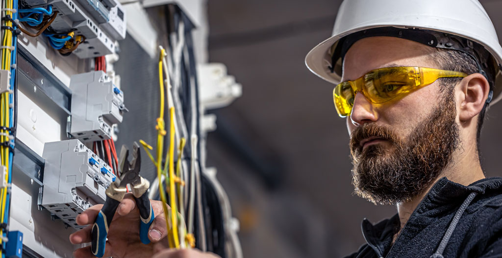 Technicien fibre optique vérifiant une installation dans une armoire technique